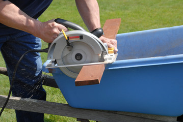 Carpenter cutting wood with a circular saw. Handyman using a power tool to cut lumber