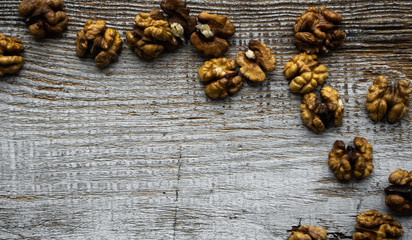 Walnut scattered on the wooden vintage table. Walnuts is a healthy vegetarian protein nutritious food. Walnut on rustic old wood. Copy space.