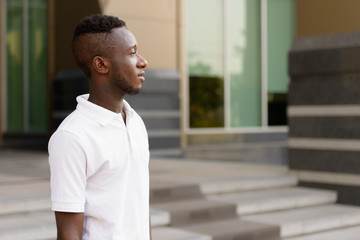 Obraz premium Profile view of young African man in the city outdoors