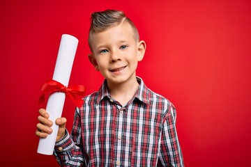 Young little caucasian student kid holding school degree over red isolated background with a happy face standing and smiling with a confident smile showing teeth