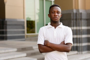 Portrait of young African man with arms crossed in the city outdoors © Ranta Images