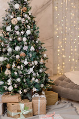 Big Christmas tree with gifts in a white room