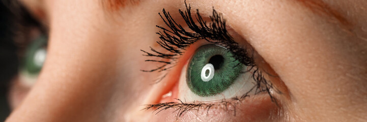 Female left blue eye tinted in green colour with special contact lens