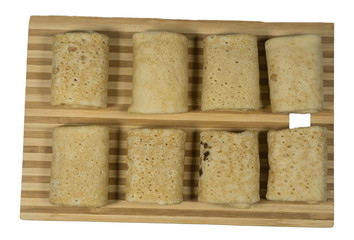 Rolled pancakes with berries on white wooden