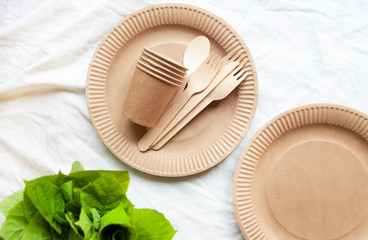 disposable eco tableware on a light background of paper cardboard spoon fork knife
