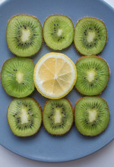 Fototapeta na wymiar green kiwi and yellow lemon on grey background