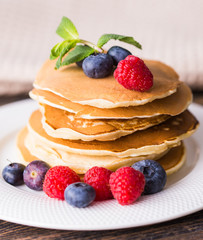 Homemade american pancakes with fresh blueberry and raspberries. Healthy morning breakfast. Rustic style