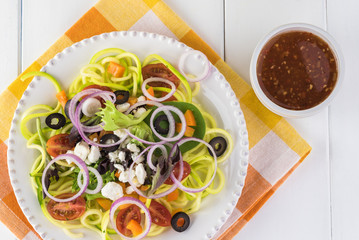 Spiral zucchini noodles salad with variety vegetables.