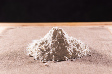Heap of dry flour on textile. Cooking flour products concept.