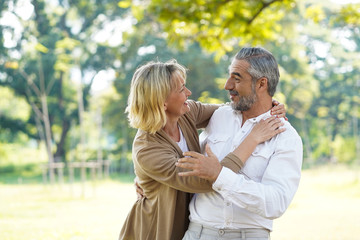 Happy senior couple hug and take care together with good relationship and good health in the park...