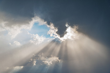 Sunlight breaks through the stormy clouds before the rain.