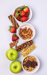 Bowls with Granola or Muesli Bowl with Strawberry and Almond Muesli Bars Blue Background Healthy Diet Breakfast Top View Flat Lay Vertical