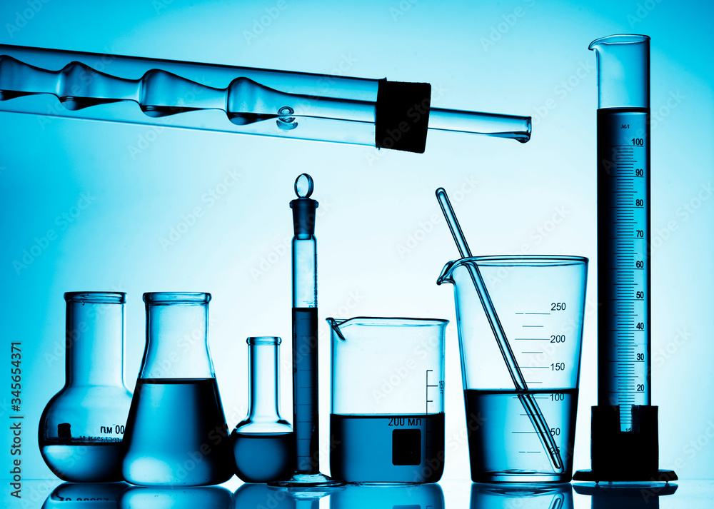 Wall mural different laboratory glassware with color liquid and with reflection