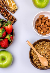 Coconut Bowls with Granola or Muesli with Wooden Spoon Bowl with Ripe Strawberry and Almond Green Apple Muesli Bars Blue Background Healthy Diet Breakfast Top View Vertical