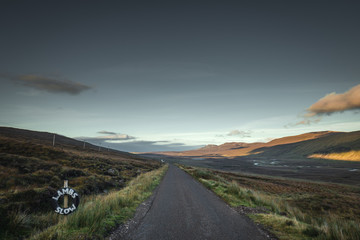 Rural Road Across Scottish Highlands at Sunset