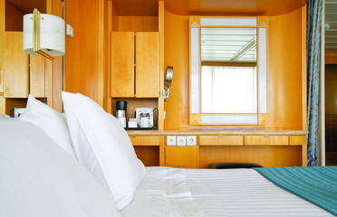 Bedroom with double bed inside suite onboard cruiseship or cruise ship liner