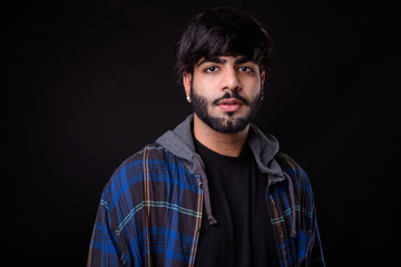 Portrait of young handsome bearded Indian hipster man