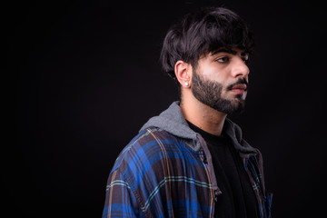 Portrait of young handsome bearded Indian hipster man