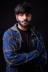 Portrait of young handsome bearded Indian hipster man