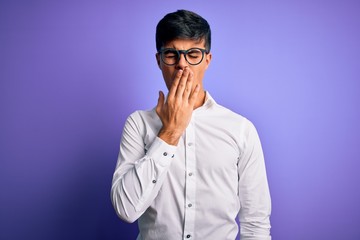Young handsome business man wearing shirt and glasses over isolated purple background bored yawning tired covering mouth with hand. Restless and sleepiness.