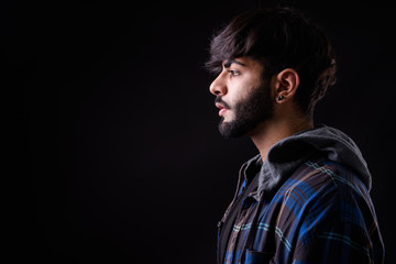 Portrait of young handsome bearded Indian hipster man