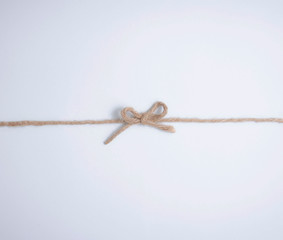 Single bow knot on a linen rope isolated on white background