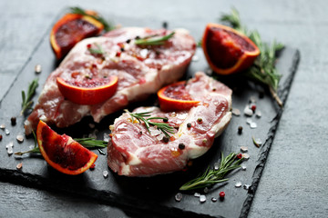 Pork steaks marinated with rosemary and red orange. Raw meat. Keto Paleo. Pegan diet. Pork with citruses. Recipe. Selective focus. Macro.