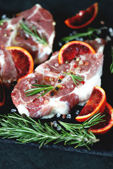 Pork steaks marinated with rosemary and red orange. Raw meat. Keto Paleo. Pegan diet. Pork with citruses. Recipe. Selective focus. Macro.