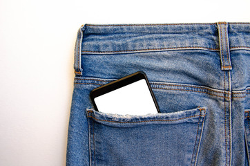 White screen smartphone in jeans pocket. Smartphone place for text. Smartphone in a pocket on a white background.  Copy Space