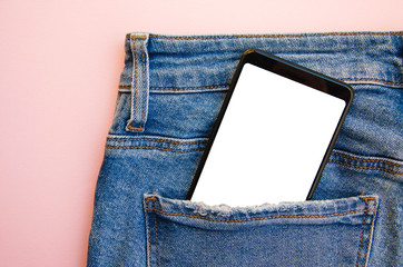 White screen smartphone in jeans pocket. Smartphone place for text. Smartphone in a pocket on a pink background.  Copy Space