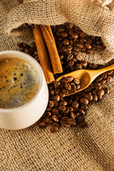 Coffee on wooden spoon on a burlap textured background