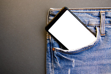 White screen smartphone in jeans pocket. Smartphone place for text. Smartphone in a pocket on a black background.  Copy Space