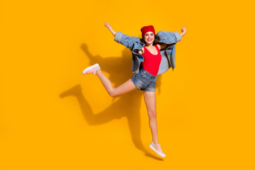 Fototapeta na wymiar Full size photo of cheerful carefree youngster girl jump raise hands enjoy spring weekend free time holidayn wear good look singlet headwear sneakers isolated over bright color background