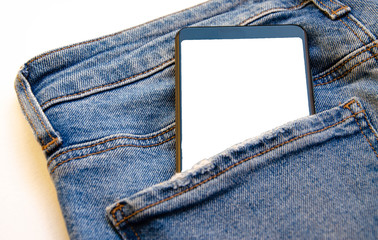 White screen smartphone in jeans pocket. Smartphone place for text. Smartphone in a pocket on a white background.  Copy Space