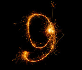 number nine written with a sparkler on a black background