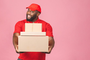 Delivery concept. African american delivery black man carrying parcel isolated over pink background.