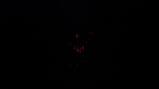 Fire growing in a fire basket at night