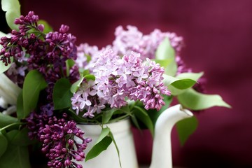 lilac bouquet in a jug on a purple background. place for text. copy space