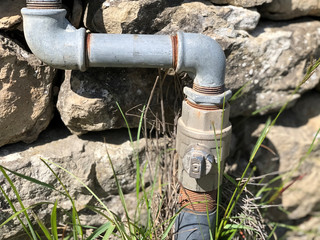 Home gas tube close-up across stone wall. Gas equipment. Gas infrastructure