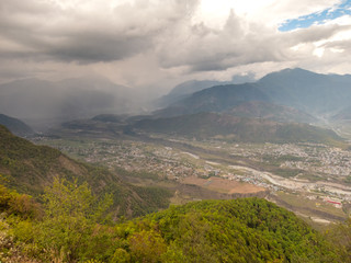Obraz premium A scenic, aerial view of dark clouds hanging over the valley below the Himalayan village of Sarangkot near Pokhara in Nepal.