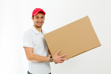 Smiling young delivery man holding and carrying a cardbox isolated on white background - obrazy, fototapety, plakaty