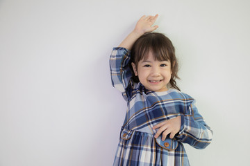 half-body and front-view photo of adorable, three-year-old Asian girl posing on a white background shows her brightness that makes people look happy, bright and cute.