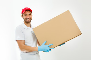 Smiling young delivery man holding and carrying a cardbox isolated on white background