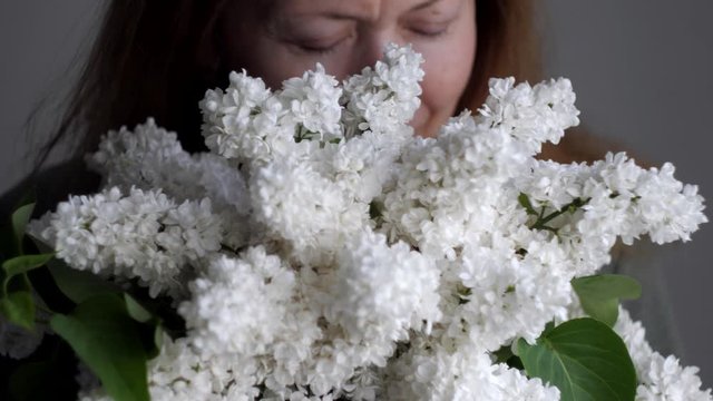woman with bouquet of white lilacs flowers