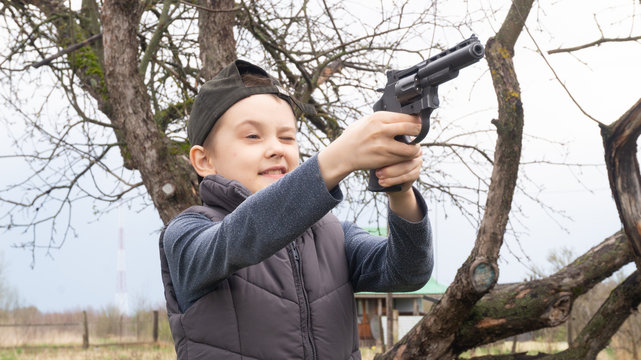 a boy in a black cap shooting a pistol at targets. weapon. sport shooting.