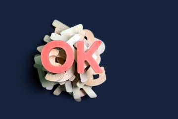 Letters, abbreviation OK or okay on pile of wooden letters. Positive decision concept