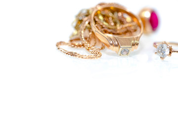 Real gold rings, diamonds , gems on white shiny surface close up macro shot.