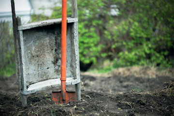 Spade and garden stretcher on the agricultural field background.