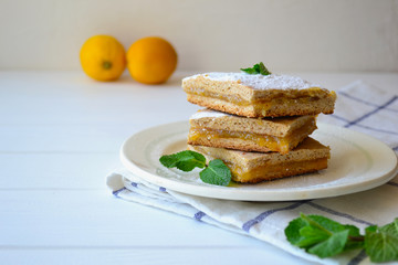 Thin lemon tart with soft filling and sugar powder.  Horizontal orientation with a copy space.
