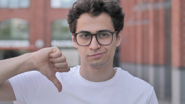Thumbs Down by Young Man Standing Outdoor